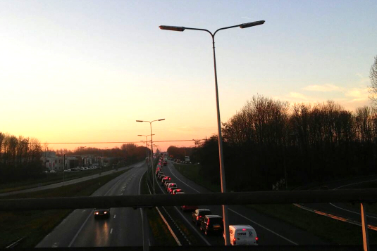 In de file op Eemshavenweg bij Noordzeebrug, terwijl de zon opkomt…