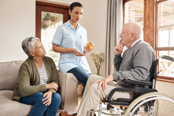 Cropped shot of an attractive young female nurse giving medication to an elderly male tenant at an old age home