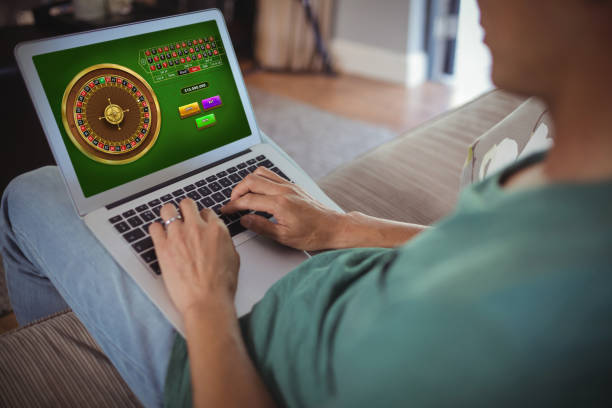 Online Roulette Game  against midsection of man using laptop in living room