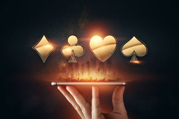 Creative background, online casino, in a man's hand a smartphone with playing cards, roulette and chips, black-gold background. Internet gambling concept. Copy space.