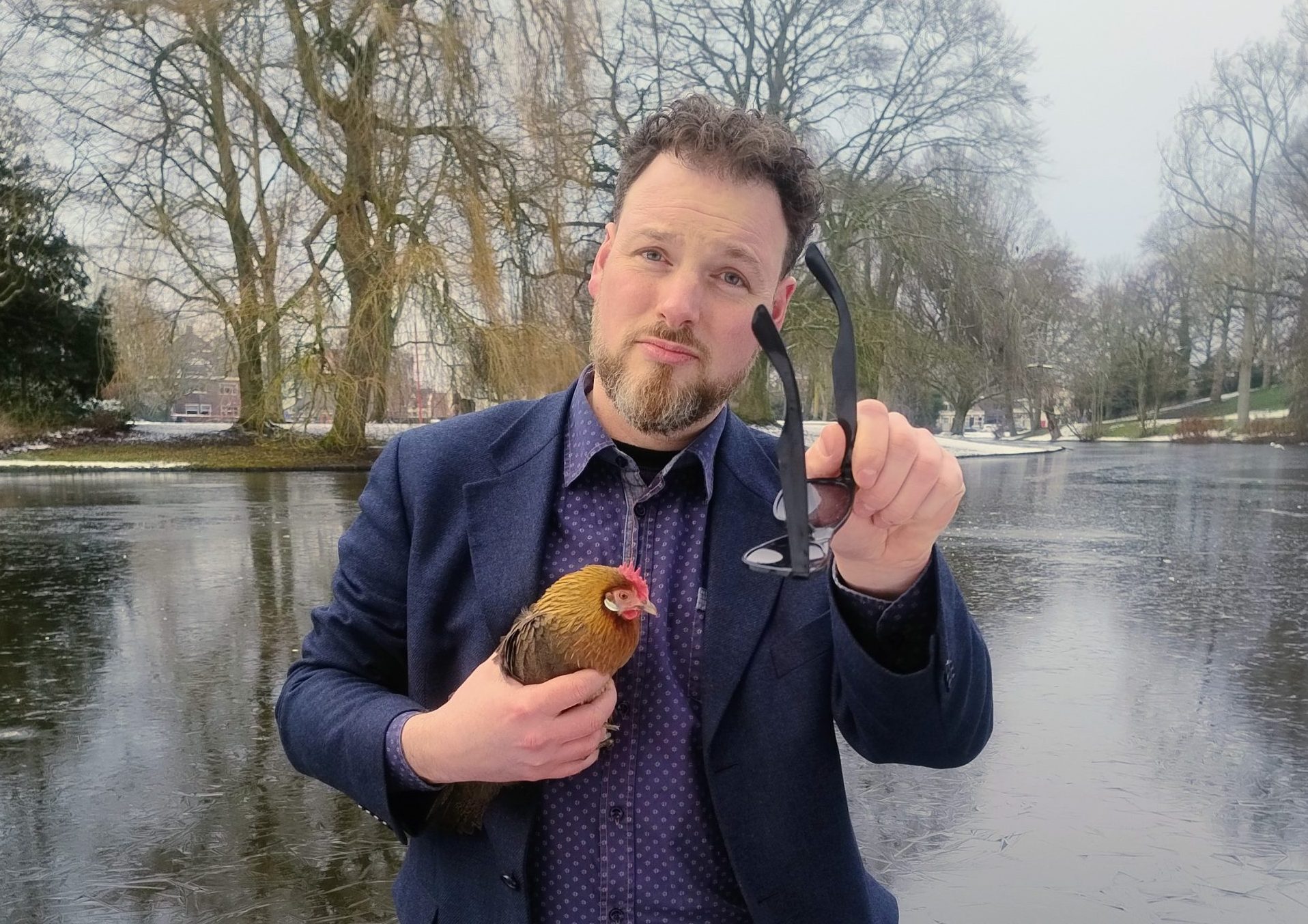 Foto | Carel Lenferink in het Noorderplantsoen met zijn kip Chilly. Hij staat in het water om op te komen voor de vrijheid van Groningers. 